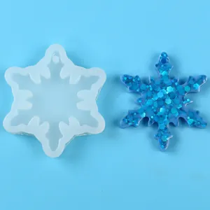 Snowflake silicone mold shown next to a finished glittery blue resin ornament.