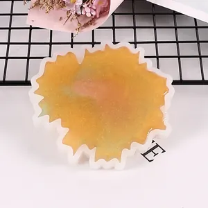 Close-up of irregular wave-edged silicone mold with gold glitter resin finish