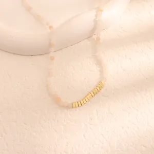 Vista macro di una collana vintage di perline con accenti quadrati in metallo dorato