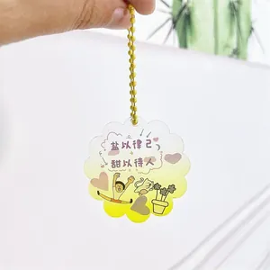 Main tenant un porte-clés créatif en acrylique dégradé avec citations chinoises