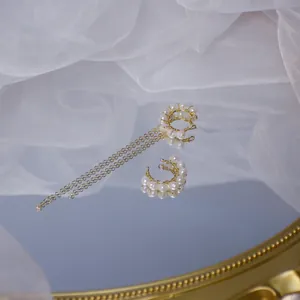 Détail de manchette d'oreille en or 14 carats avec perles d'eau dolce et pompon