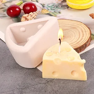 Vista detallada de un molde de silicona con forma de queso y una vela de queso amarilla