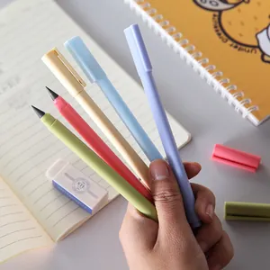 Set of five colorful eternal inkless pencils held by hand over a desk.