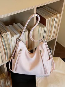 Stylish pink large capacity hobo shoulder bag for women on a cozy bookshelf background.