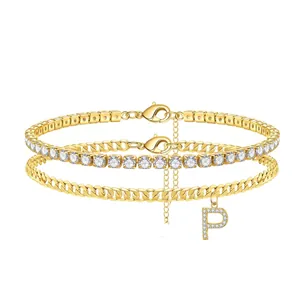 Detailed view of gold double-layer anklet featuring tennis chain and stone-set P initial charm