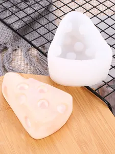 Detalle de un molde de silicona con forma de queso triangular y vela de yeso artesanal decorativa