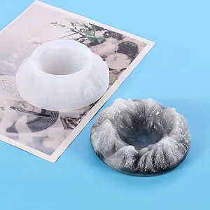 Dettaglio di uno stampo in silicone bianco e di un posacenere in resina a forma di montagna