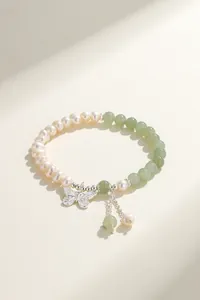 Detailed macro view of natural freshwater pearl bracelet featuring a silver butterfly charm.