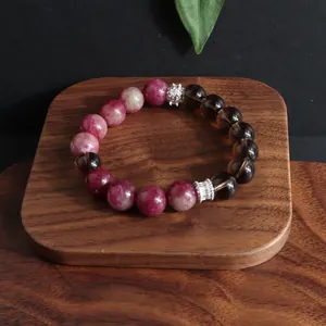 Primer plano detallado de una pulsera de cuarzo ahumado y turmalina natural en madera