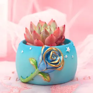Handmade blue succulent flower pot with rose relief and pink plant for home table decor