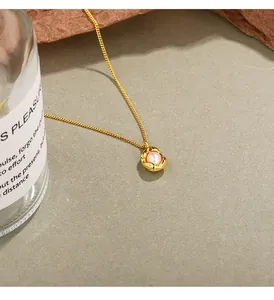Close-up of elegant gold pearl necklace with irregular textured pendant design