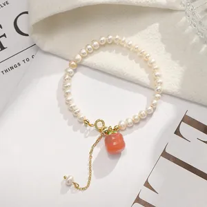 Detailed macro view of freshwater pearl bracelet with carnelian persimmon charm