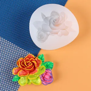 Close-up detail of a white floral silicone mold and its colorful painted rose plaster decoration