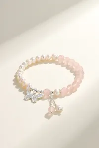 Detailed view of natural pearl bracelet with silver butterfly charm and pink beads