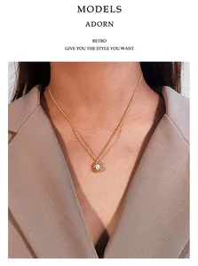 Close-up detail of retro pearl necklace with irregular gold pendant on model's neck