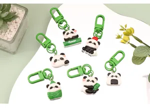 Detailed view of six cartoon panda resin keychains with green clasps on a white board