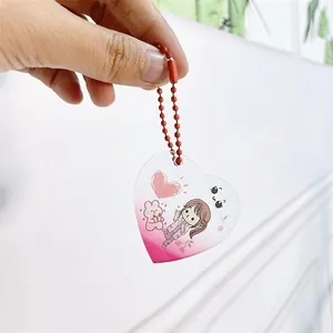 Vue détaillée d'un mignon porte-clés en acrylique en forme de cœur avec illustration