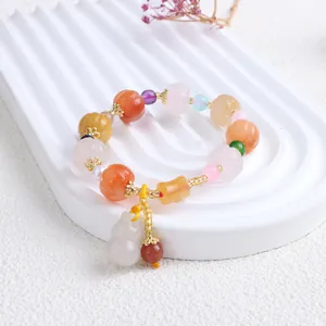 Detailansicht eines Naturjade-Armbands mit kürbisförmigen Perlen und weißem Kürbisanhänger.