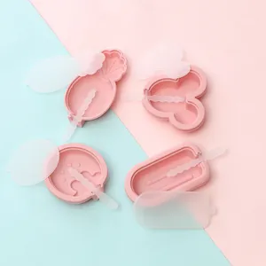 Detail showing various shapes of pink silicone popsicle molds with lids and sticks