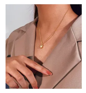 Close-up of a vintage irregular pearl necklace worn on a woman with a beige blazer.