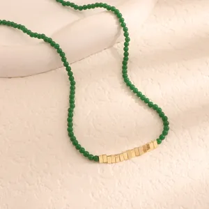 Primo piano di una collana di perline verdi in stile vintage con accenti dorati rettangolari