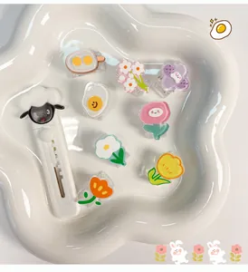 Eine Sammlung von süßen Cartoon-Acrylclips und Schaf-Cutter in einer Blumenschale