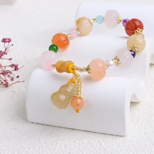 Detaillierte Nahaufnahme eines Jade-Armbands mit Kürbisperlen und einem Kürbis-Anhänger