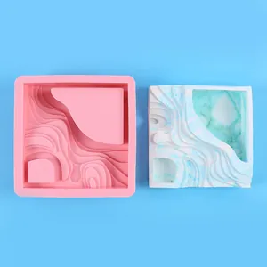 Vue détaillée du moule en silicone rose à motifs ondulés et du pot en plâtre fini