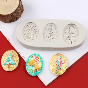3-cavity Christmas silicone mold with finished tree and bell fondant decoration samples.