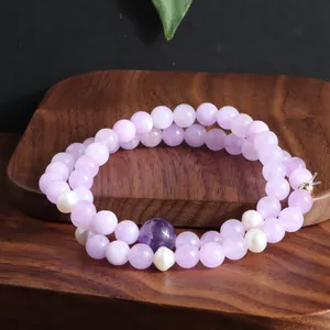 Detailweergave van een dubbelstrengs Kunziet kristallen armband met zoetwaterparels.
