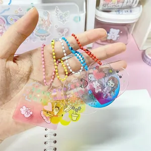 Détail de porte-clés DIY en acrylique scintillant avec dégradé et petite chaîne colorée.