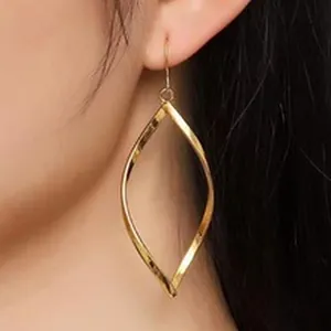 Elegant gold twisted leaf drop earring shown on model ear for style reference