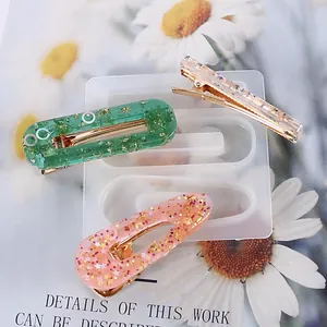 Vue détaillée du moule en silicone avec des barrettes en résine pailletée sur fond floral