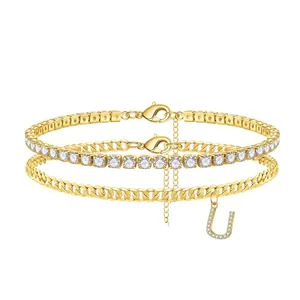 Detail of gold-layered anklet with zircon tennis chain and pave 'U' initial charm.