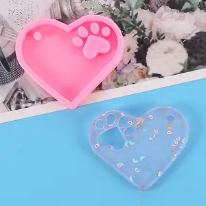 Detail of heart-shaped cat paw silicone mold with finished transparent resin piece
