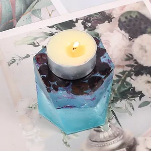 Close-up of hexagonal blue resin candle holder with embedded dried flowers and glitter