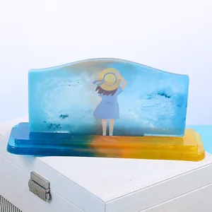 Detailed view of a creative DIY crystal resin ornament with a girl graphic and blue wave base.