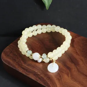 Detailansicht eines zweireihigen Jade-Armbands mit einem eleganten weißen Anhänger.