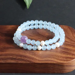 Detailweergave van een dubbele armband met blauwe aquamarijnkralen en witte parels