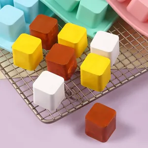 Primer plano de jabones cuadrados de colores en una rejilla con moldes de silicona