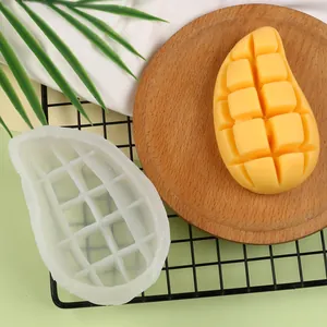 Vista detallada del molde de silicona con forma de mango y su producto de vela terminada.