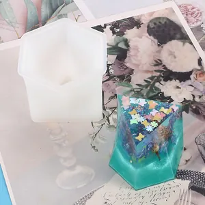 Detail view of a hexagonal silicone mold and a teal resin craft with butterflies.