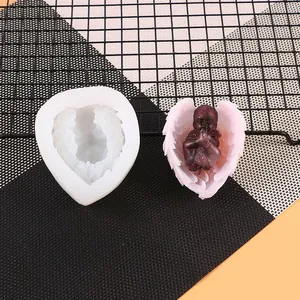 Detailed macro of heart-shaped angel silicone mold and finished pink wing craft