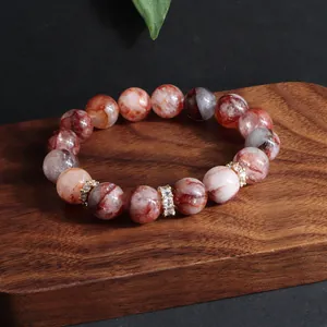 Makroansicht eines roten Hämatoidquarz-Armbands mit funkelnden Zirkonia-Ringen