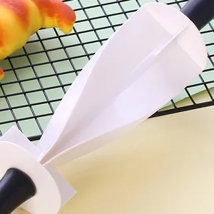 Close-up of a white plastic multifunctional croissant cutter roller for baking crescent rolls