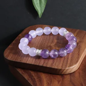 Detalle de pulsera de amatista natural y cuarzo lavanda sobre una bandeja de madera