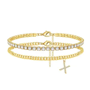 Detail view of double-layer gold anklet with sparkling tennis chain and pavé initial X