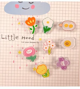 Nahaufnahme verschiedener süßer Cartoon-Acrylclips auf einem hübschen Karohintergrund