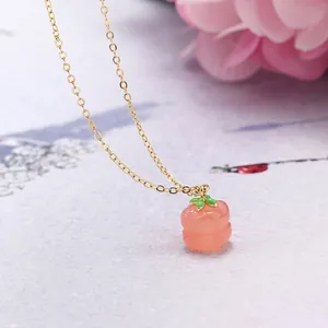 Elegant gold chain necklace with a translucent pink persimmon agate pendant charm