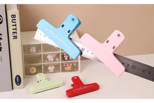 Dettaglio delle clip magnetiche color Morandi che tengono un righello metallico sulla scrivania